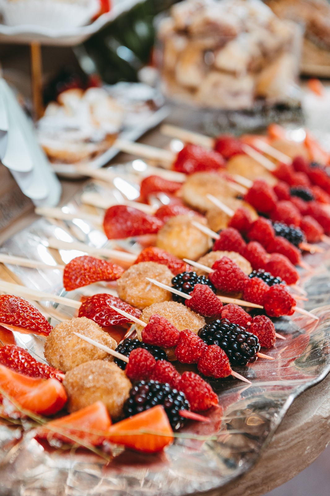 Brochetas de frutos rojos y repostería artesanal en una mesa de brunch