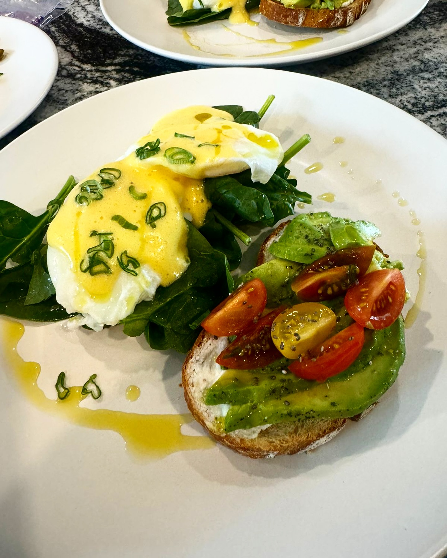 Huevos benedictinos con espinaca y pan tostado con aguacate y jitomates