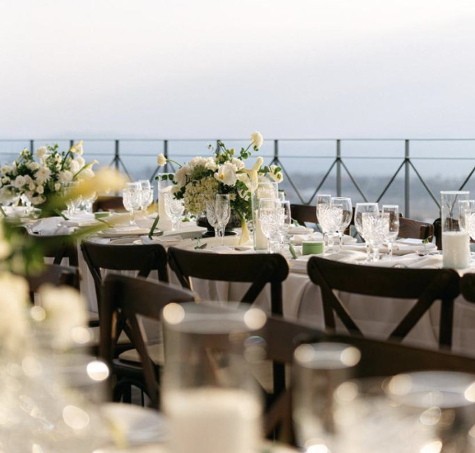 Banquete de boda al aire libre con mesas blancas y flores